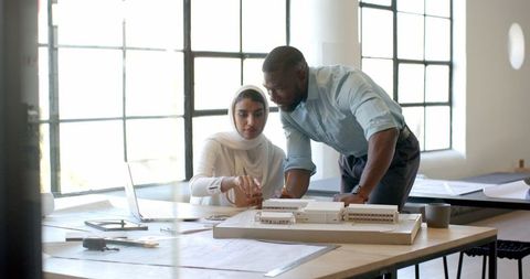 Colleagues Collaborating on Architectural Project in Modern Office