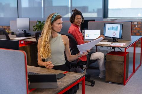 Coworkers Analyzing Reports in Modern Office