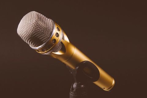 Golden microphone on stand isolated against dark background