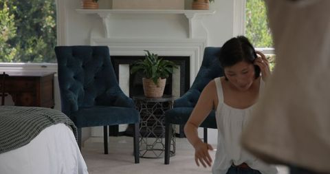 Asian Woman Talking on Phone in Cozy Living Room Setting