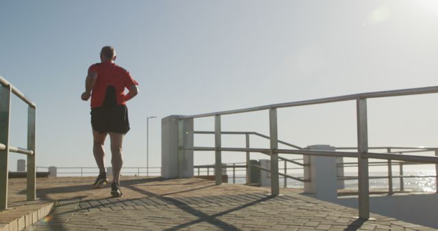 Man Running on Seaside Promenade on Sunny Day - Download Free Stock Images Pikwizard.com