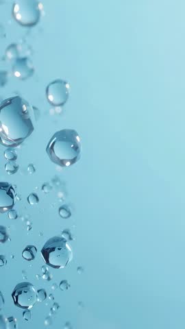 Vertical macro video showing rising water droplets on pale blue backdrop with copy space