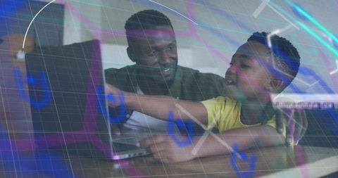 Father and son learning together on laptop at home