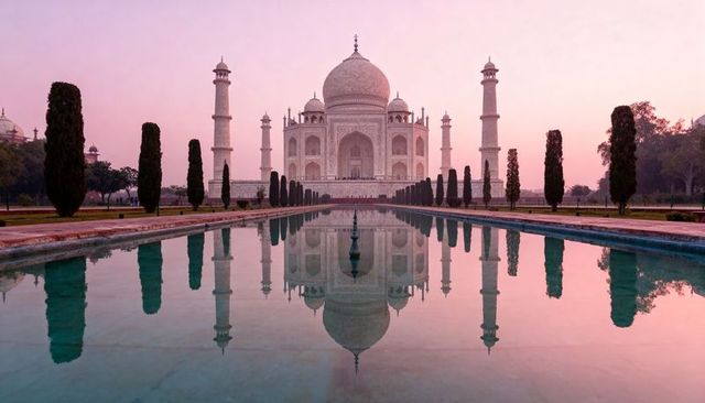 Taj mahal at sunrise with reflecting pool, symmetrical architecture and pink sky