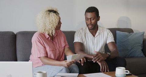 African American Friends Discussing Documents on Couch at Home