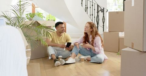 Couple unpacking in new home surrounded by boxes
