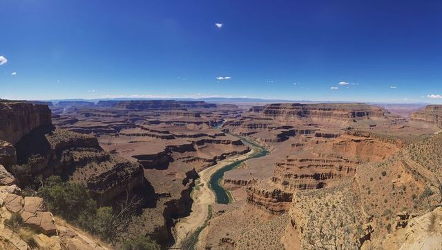 Panoramic canyon overlook showing winding river and layered red rock cliffs