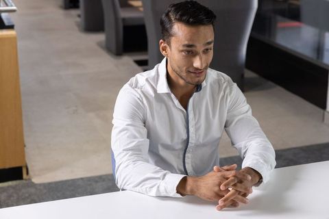 Confident businessman sitting in modern corporate lounge area