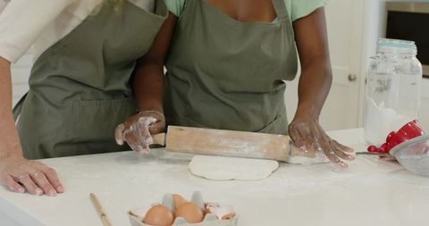 Diverse Friends Rolling Dough Together in Modern Kitchen