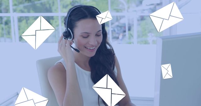 Smiling woman wearing a headset, surrounded by floating envelopes, depicting email communication. Ideal for use in business or tech advertising, demonstrating customer service, remote support, or online communication solutions in corporate settings.