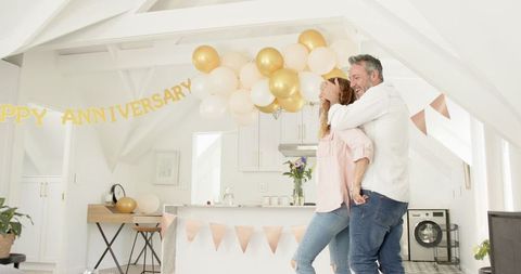 Joyful Anniversary Celebration with Mature Couple in Decorated Home