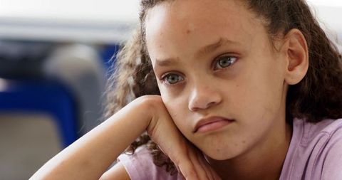 Pensive african american schoolgirl resting head on hand closeup for education wellness