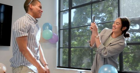 Smiling Businesswoman Taking Photo at Office Celebration