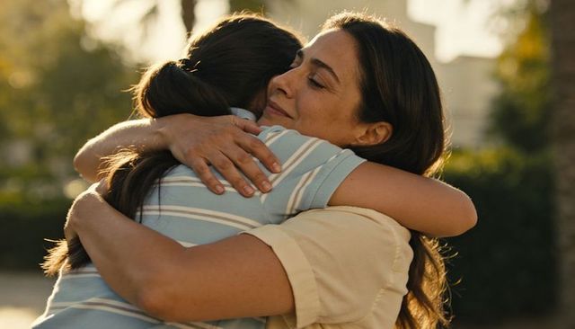 Mother and daughter sharing warm embrace during golden hour backyard reunion