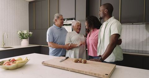 Multigenerational family with african american couple laughing in modern kitchen