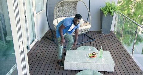 Man arranging balcony seating with refreshments afresh