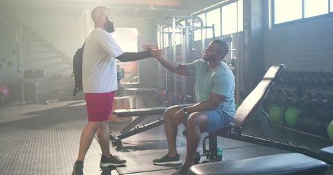 African american men shaking hands in gym after workout, fitness camaraderie and training