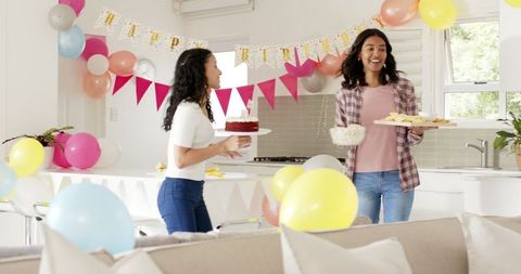 Women Preparing for Birthday Celebration at Home with Cake and Snacks