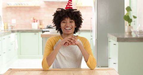 Cheerful woman sitting in modern kitchen smiling