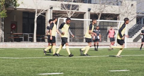 Soccer Players Preparing on Field in Black and Yellow Uniforms