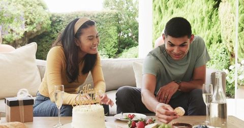 Happy Couple Enjoying Anniversary with Cake and Champagne Outdoors