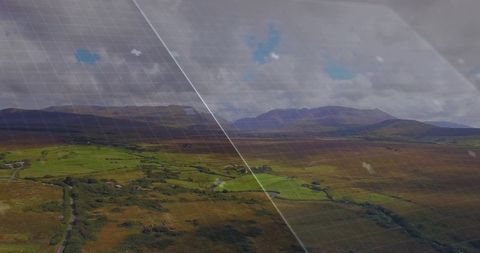 Aerial patchwork valley with grid overlay and winding country lane under moody skies
