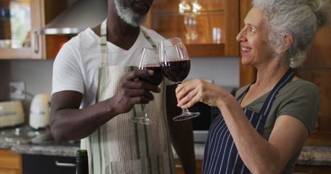 Senior Couple Toasting with Wine in Cozy Home Kitchen
