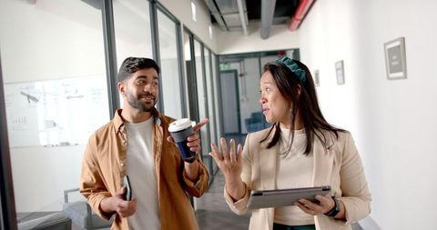 Colleagues engaging in workplace discussion over coffee