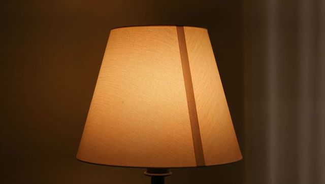 Glowing beige lampshade casting warm amber light for cozy bedroom ambience and decor