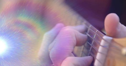 Close Up of Guitarist Strumming with Vibrant Lighting Effects