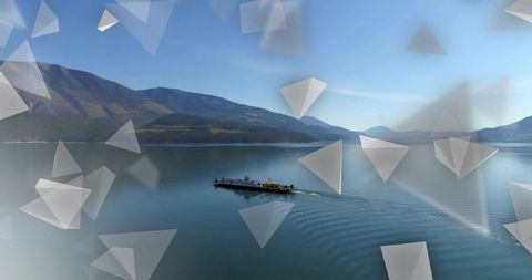 Cargo barge gliding across calm mountain lake with abstract triangular overlays