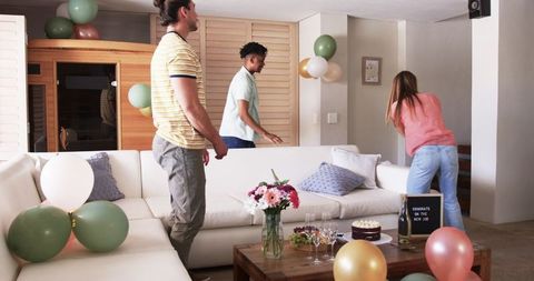 Friends Decorating Living Room for Celebration Gathering