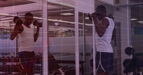 Lifting dumbbells in mirror with fitness data overlay for strength training focus
