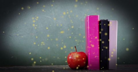 Glowing spots with books and apple hinting literacy day