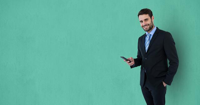 Digital composite of Happy businessman holding smart phone against green background