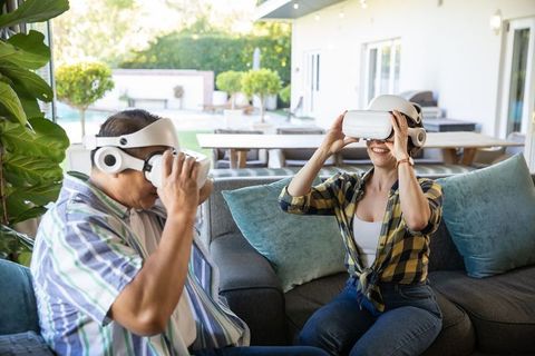 Senior Couple Enjoying Virtual Reality Together Outdoors