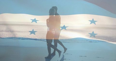 Couple walking on beach with translucent honduras flag overlay and shoreline footprints