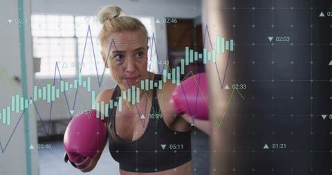 Female boxer punching heavy bag wearing pink gloves with performance chart overlay