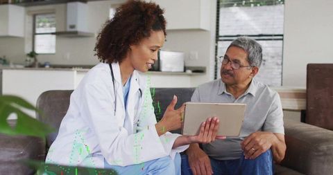 Doctor Discussing with Patient Using Tablet at Home Setting