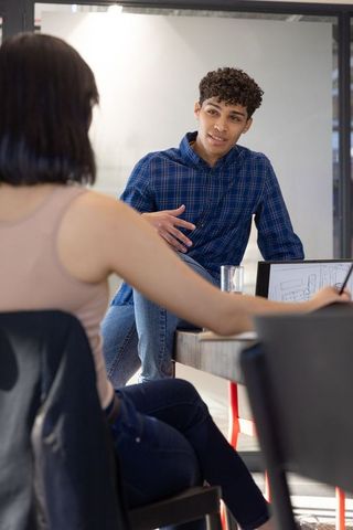 Diverse coworkers collaborating on laptop sketches