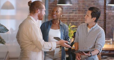 Diverse Team Brainstorming with Tablets in Modern Open Office
