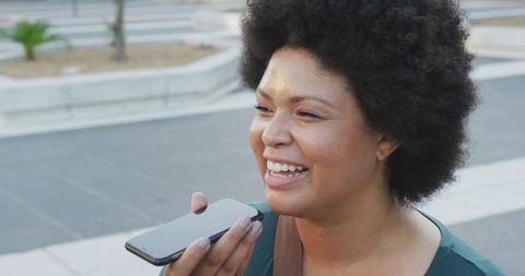 Happy Biracial Woman Using Smartphone in Urban Environment