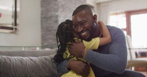 Loving Father and Daughter Embracing on Comfortable Sofa