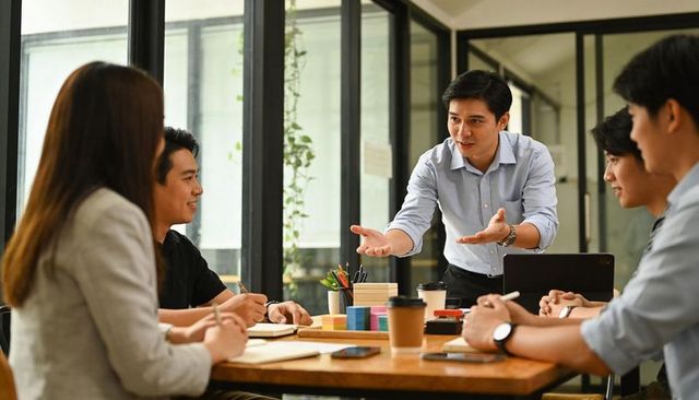 Businessman leading team, presenting ideas during collaborative office brainstorming session