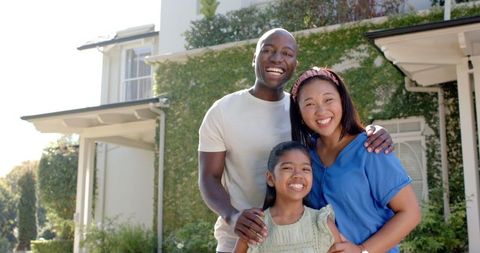 Happy Family Bonding Outside Home in Sunny Neighborhood