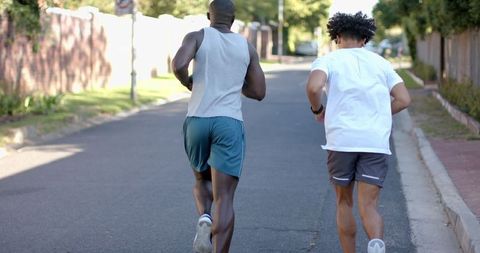 Diverse Male Friends Jogging in Suburban Street Promoting Fitness and Friendship
