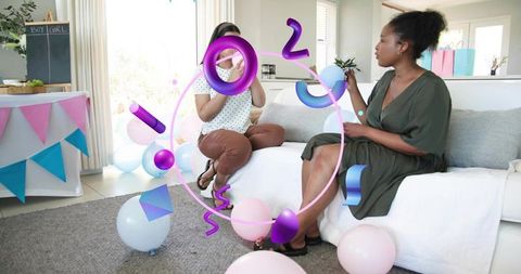 Reacting friends during pastel gender reveal celebration on living room sofa with balloons