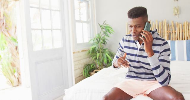 Young Man Talking on Smartphone in Bright Living Room - Download Free Stock Images Pikwizard.com