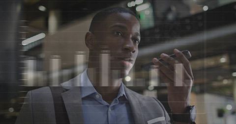 Businessman Using Smartphone for Voice Message in Modern Office