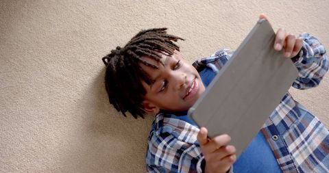 Cheerful Boy Enjoying Tablet Technology on Carpet